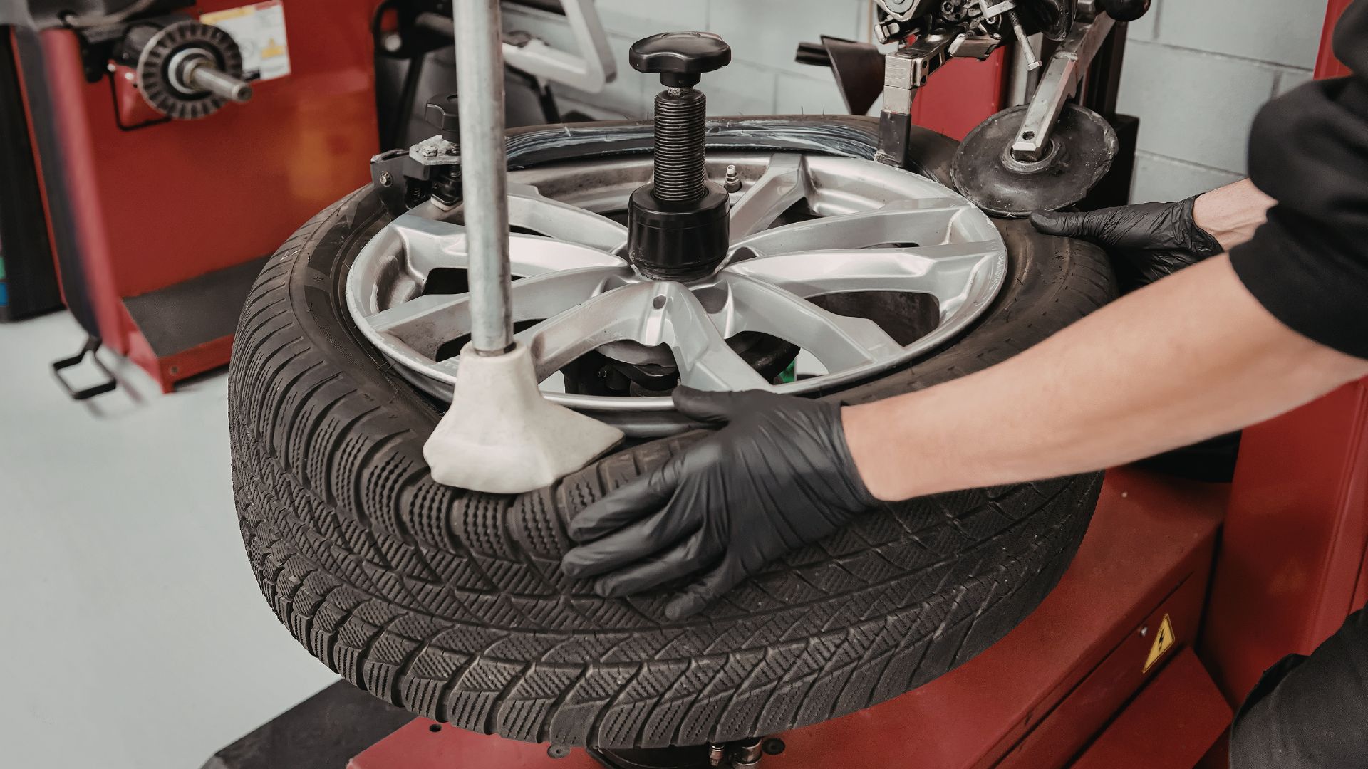 Mechanic repairing a punctured tyre in Northampton with a nail in the tyre.