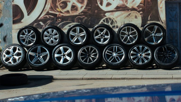 Customer checking tyre size on sidewall with mechanic helping in garage.