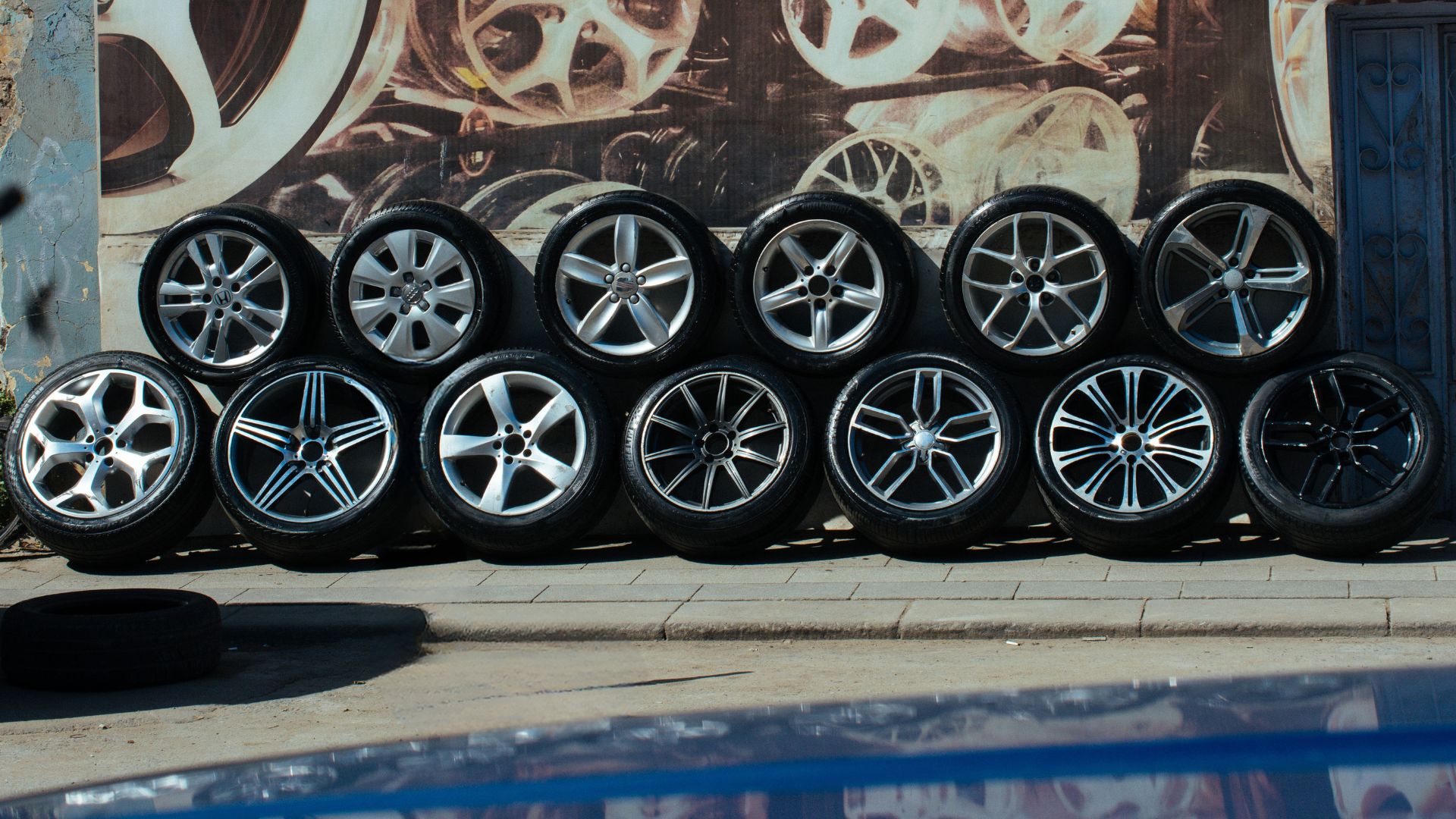 Customer checking tyre size on sidewall with mechanic helping in garage.